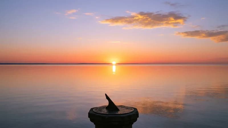 Dawn over the sea with a sundial — a symbol of the solar return