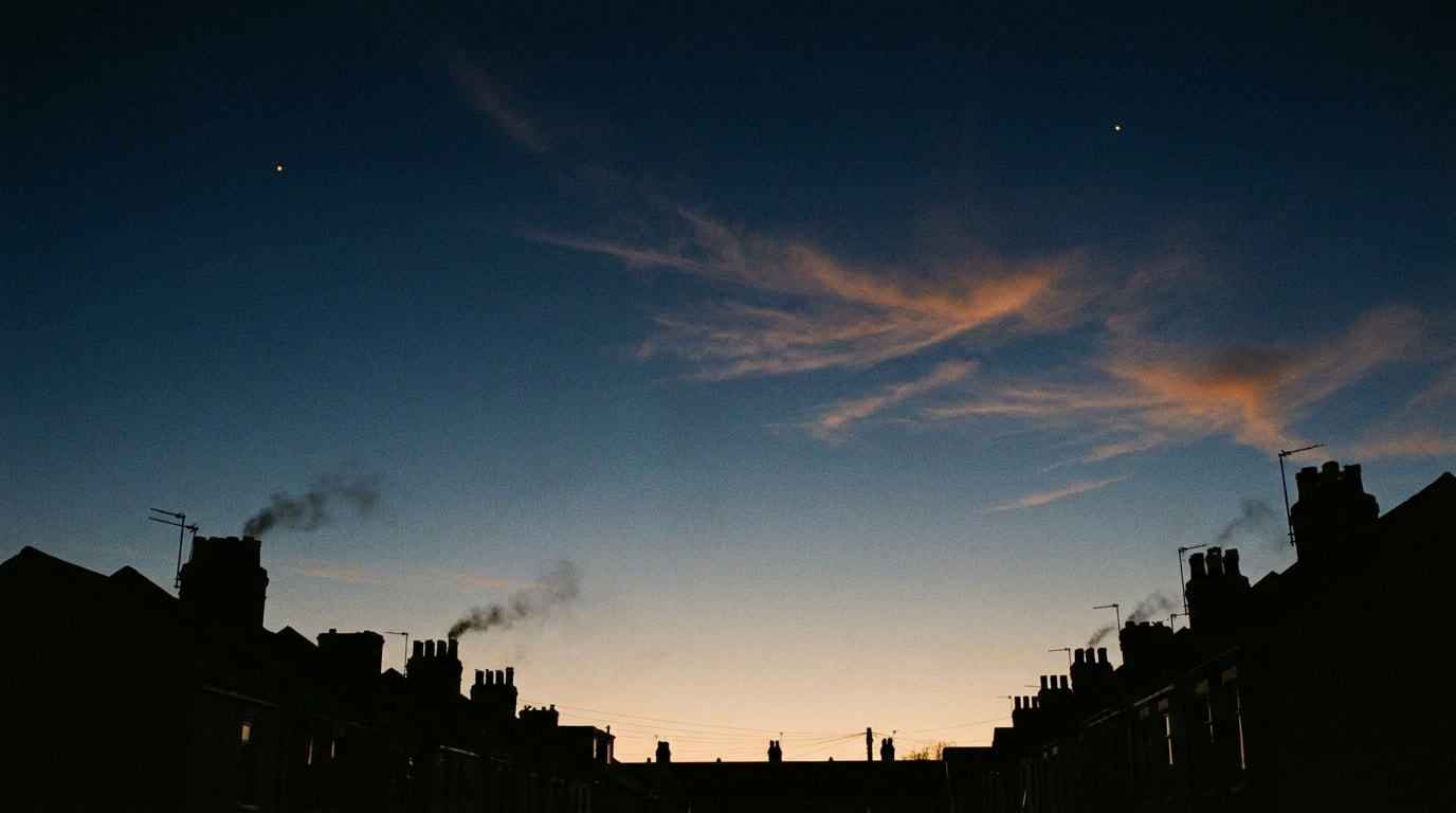Twilight sky over a row of UK rooftops with the first evening stars showing — sky as a recurring rhythm rather than a one-off event